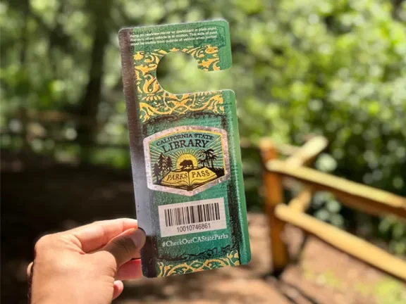 Person holding California Library Park Pass at Samuel P Taylor State Park