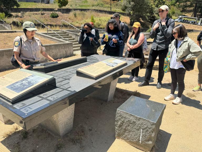 State Park Interpreter Cynthia Pu demonstrates what an immigration interrogation may have looked like at Angel Island.