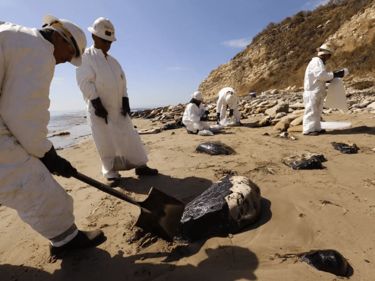 An environmental cleanup crew removes oily sand at Refugio State Beach in Santa Barbara County in May 2015 after a massive spill from a ruptured pipeline. (Los Angeles Times)