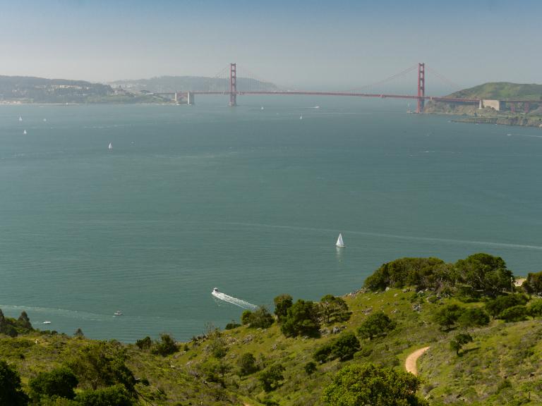 Wide sweeping view of the Golden Gate Bridge, city of San Francisco, and surrounding bay seen from up high on Angel Island