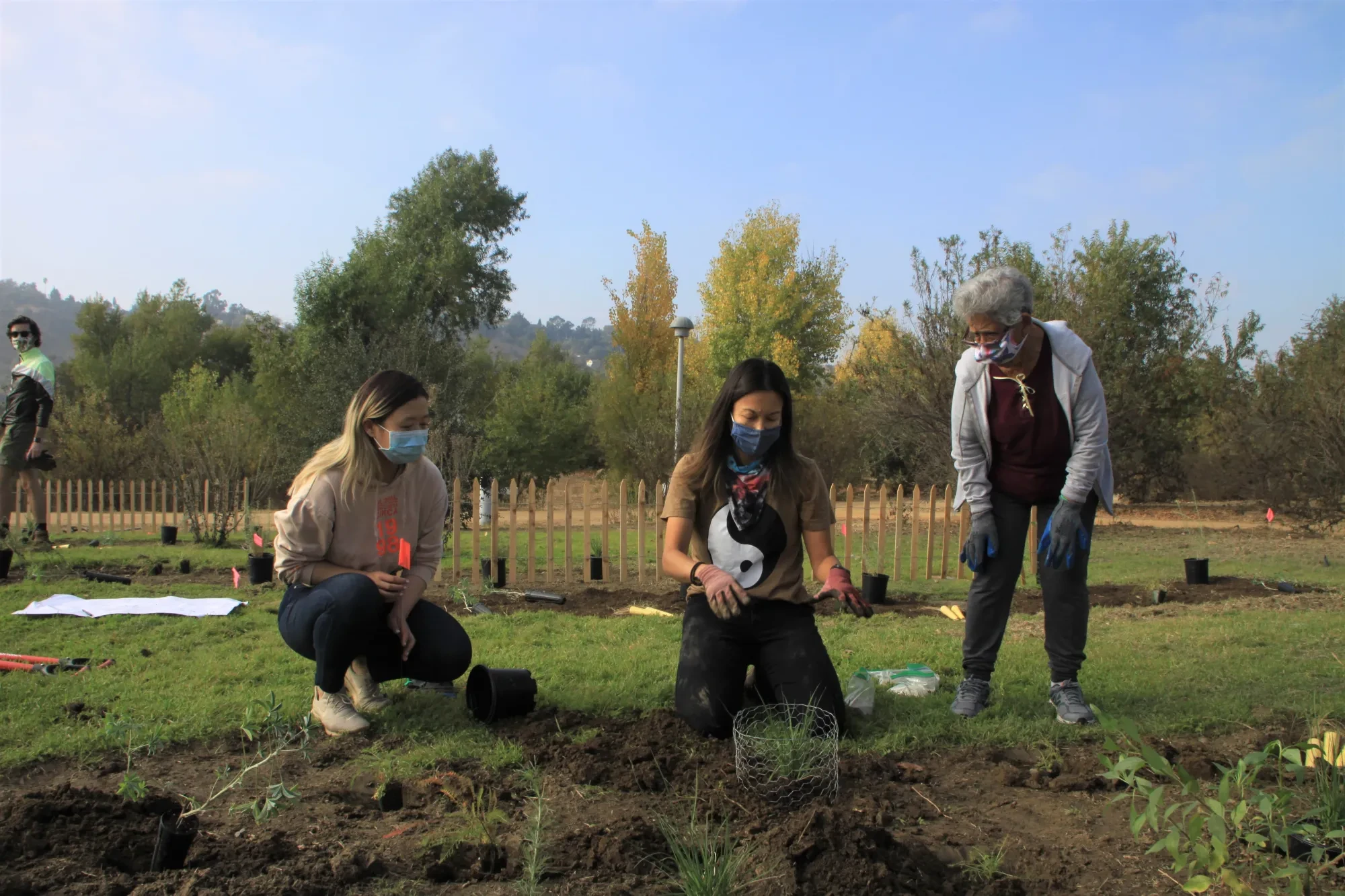 Demonstrating to volunteers how to plant native vegetation.