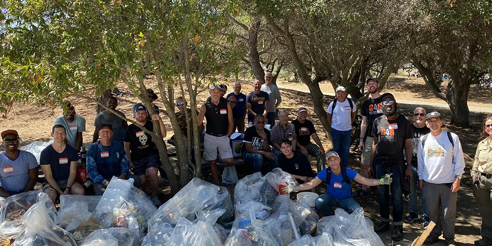 A group of volunteers with many bags of trash at Candlestick Point State Recreation Area